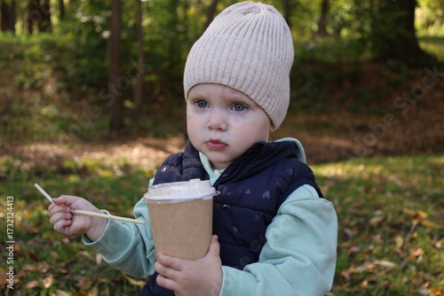A child with a glass of coffee on the street