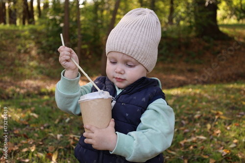 A child with a glass of coffee on the street