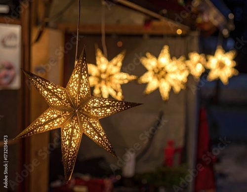 Illuminated paper stars hang from a market stall