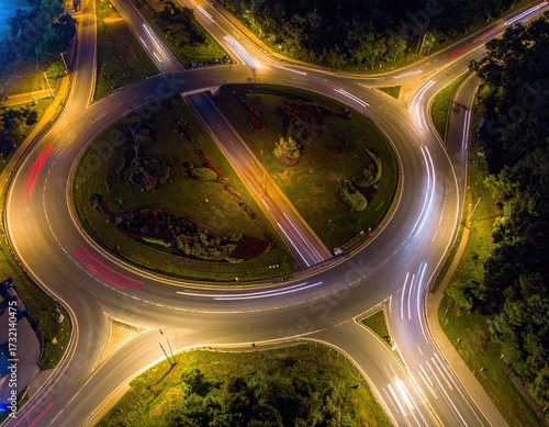 Aerial view of a roundabout at night, with illuminated traffic trails