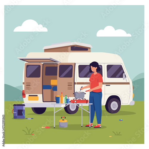 Woman cooking near campervan with open rear door on green grass, cloudy sky