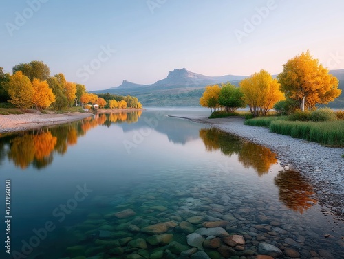 Tranquil Lake Reflecting Autumn Trees Under Clear Sky with Rocky Shoreline