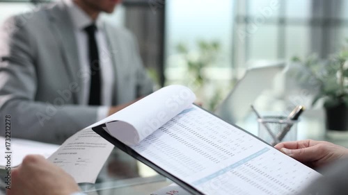 A man is sitting at a desk with a contract in front of him