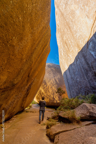 A hiker explores the top of Montanha do Açu during a long-distance trek along the Petrópolis–Teresópolis trail in the mountainous region of Rio de Janeiro, amid the rocks and bathed in the beautiful l