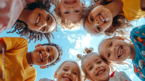 Wallpaper Mural A bunch of cheerful, joyful children playing together and having fun - a group portrait of happy kids huddling, looking down at the camera from a low angle, symbolizing friendship. Torontodigital.ca