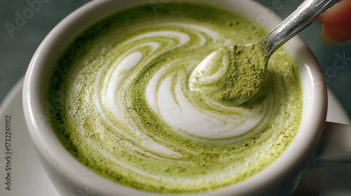 Wallpaper Mural The image showcases a close up of a cup filled with a green tinted liquid, likely a beverage, that has a visually appealing, swirled pattern of white foam Torontodigital.ca