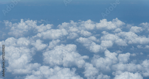 Beautiful landscape view trough window of airplane and cloudless sundown sky behind window of aircraft during flight. blue sky. Flying in the sky and the sea of clouds.