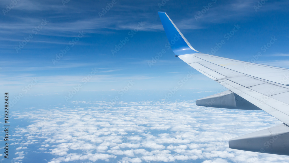 Obraz premium Beautiful landscape view trough window of airplane and cloudless sundown sky behind window of aircraft during flight. blue sky. Flying in the sky and the sea of clouds.