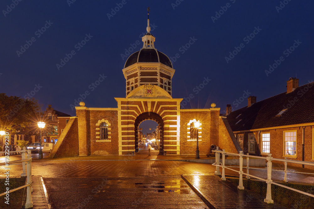 Obraz premium Historic Morspoort city gate illuminated at night in Leiden, Netherlands