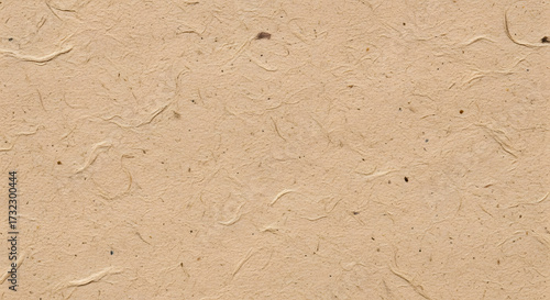 Close-up of textured beige paper with embedded fibers, creating a natural, organic, and slightly rough surface.