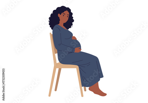 A pregnant woman sits on a lightwood chair cradling her belly