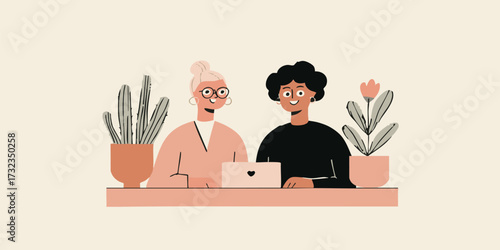 Two individuals, likely colleagues or partners, engaging in a focused discussion around a shared computer, positioned in a collaborative environment alongside potted plants.