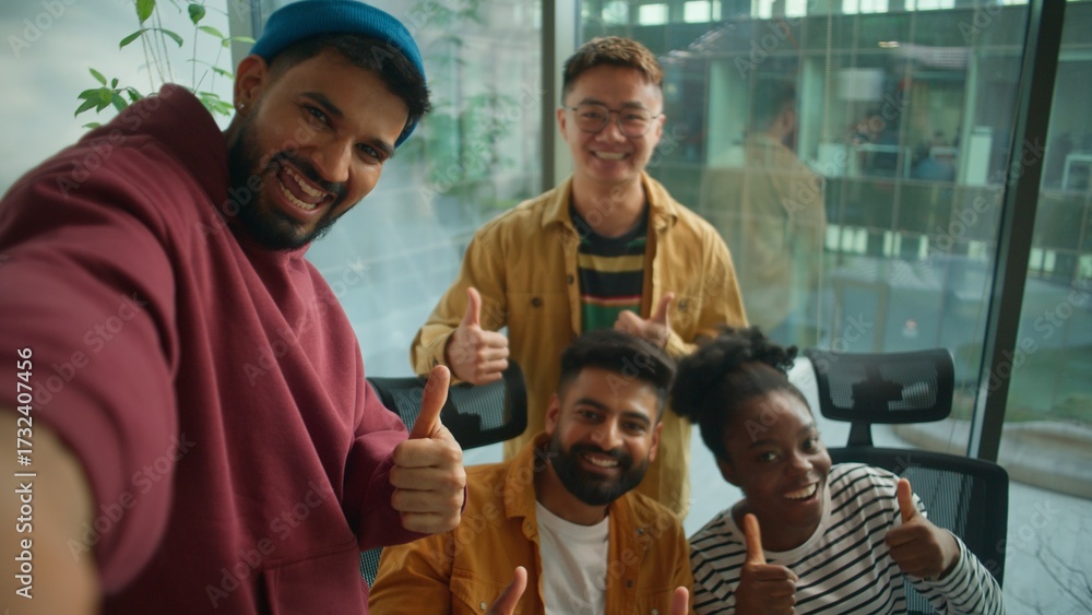Obraz premium Web cam POV four multiracial colleagues informal business team making selfie photo posing together happy smiling showing thumbs up casual corporate friends in coworking office video call live vlog