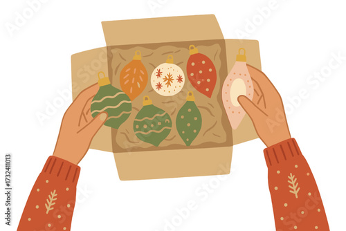 Christmas preparation concept with hands opening an old box of vintage Xmas tree balls. Top view of unpacking baubles for holiday decoration. Festive season and family tradition.