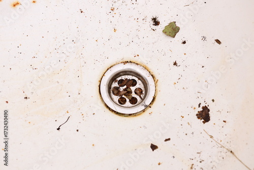 A dirty sink with a bunch of dirt and grime accumulated, suitable for use in scenes related to messy situations or everyday life