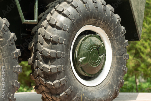 Close-up of BTR-60 armored vehicle wheels, showing massive tires, rims, and suspension elements.