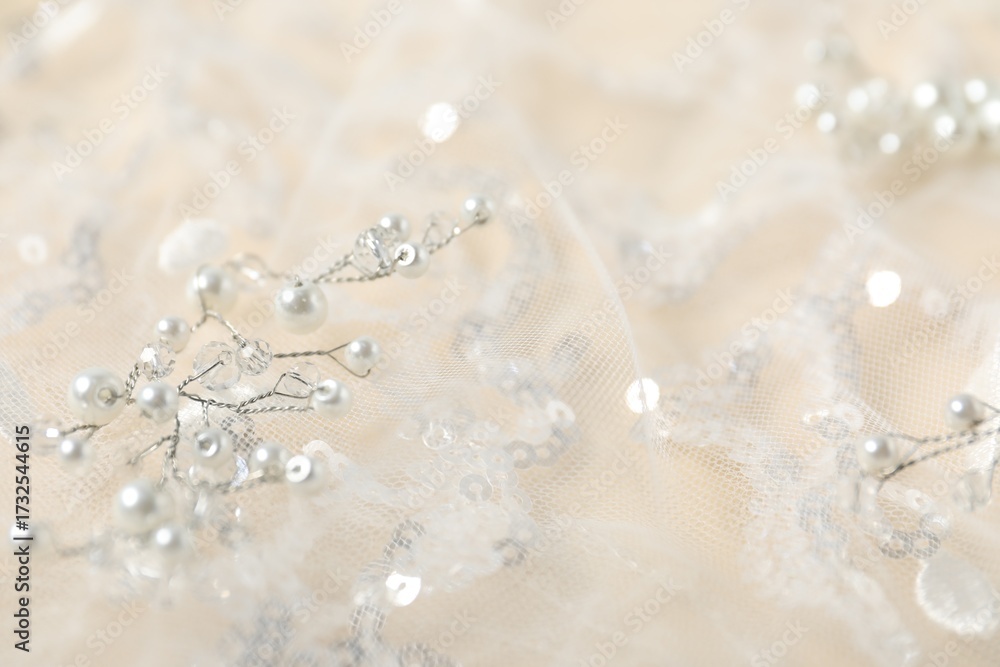 Fototapeta premium Beautiful lace fabric with sequins and pearls on beige background, closeup