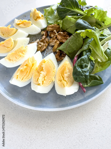 sliced boiled eggs, walnuts, fresh green salad for breakfast