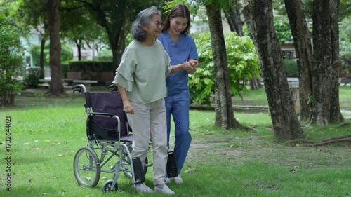 The caregiver is helping an elderly Asian woman rehabilitate her walking and monitor her condition after she underwent knee surgery, using treatment information from her doctor.