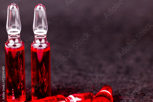 Bright red B12 ampoules arranged neatly on dark surface reflecting medical care and essential supplement.