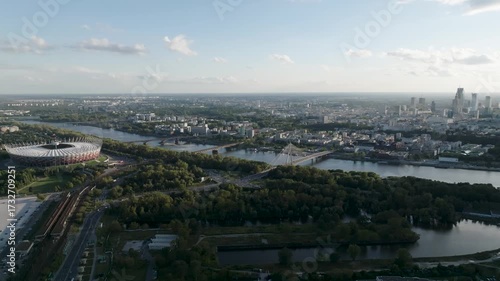 Aerial panoramic view of Warsaw city skyline with green areas and bridges over the Vistula River, Poland