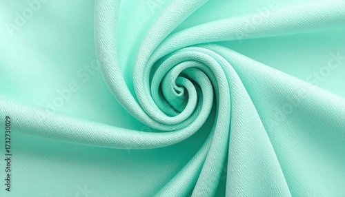 Textured Fabric Swirl: A close-up view of a smooth, light teal fabric expertly folded to create an elegant spiral or vortex pattern, showcasing its soft texture and fluid drape.