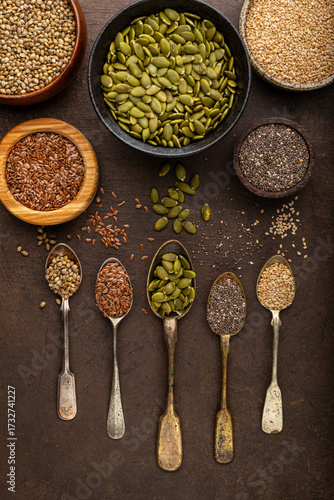 Pumpkin, sesame, flax, hemp, chia seeds in spoons and bowls, seeds for good health of mind and body, enriched with minerals and vitamins. Top view