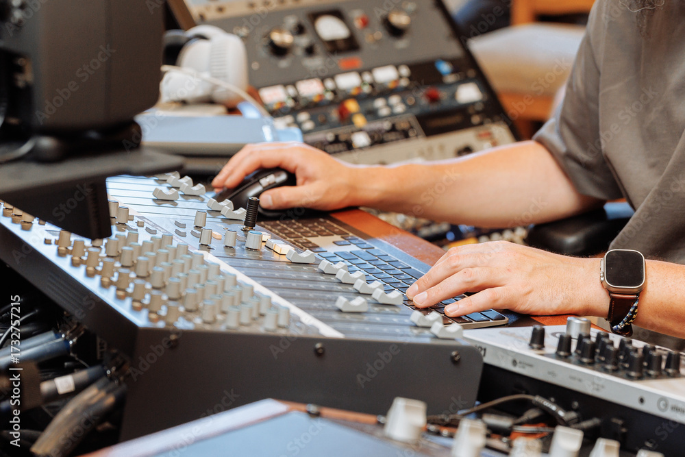 Fototapeta premium Close-up Hands of a sound engineer on mixing console.