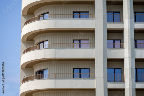 Fotografie Modern residential building with rounded balconies and cream facade