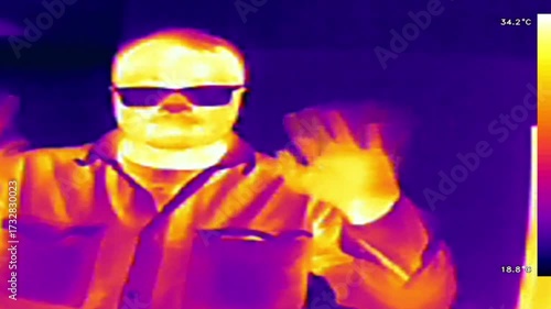 Thermal imaging camera detecting elevated body temperature. Thermography concept.  man wearing sunglasses and a shirt, heat distribution in different colors. 