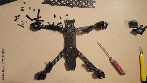 process of assembling FPV drones with various technical components laid out. A flight controller (FC) and ESC stack is being unpacked