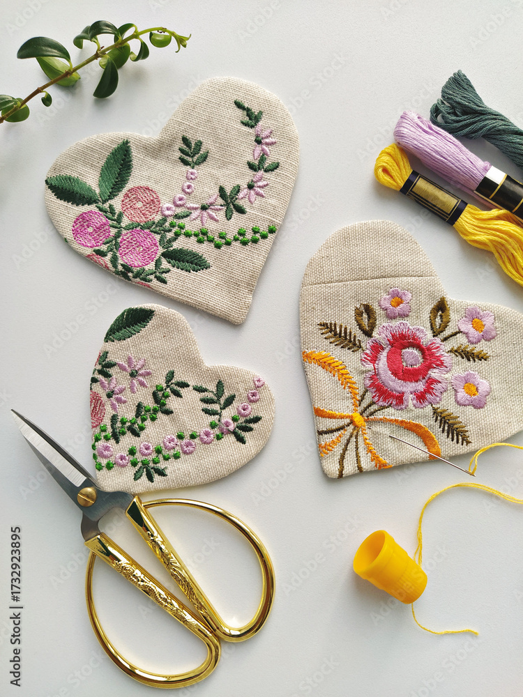custom made wallpaper toronto digitalFabric linen hearts with floral embroidery on white background, vintage scissors, needle and thread, yellow thimble, soft botanical craft mood, handmade sewing workspace flat lay