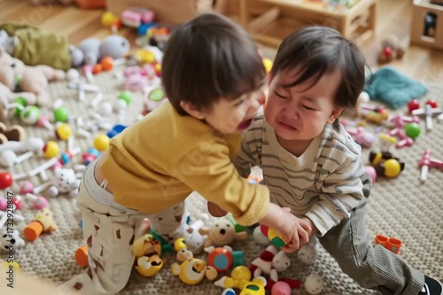 Little asian babies are fighting in the children's room at home. The relationship between siblings in the family. Adaptation of children to preschool or kindergarten conditions.