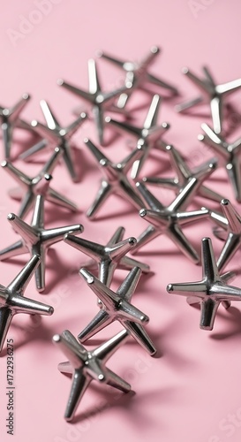Small Metal Star-Shaped Objects on Pink Background.