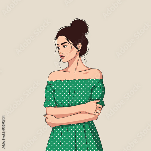 Stylish young woman with a messy bun wearing a green offtheshoulder polka dot dress.