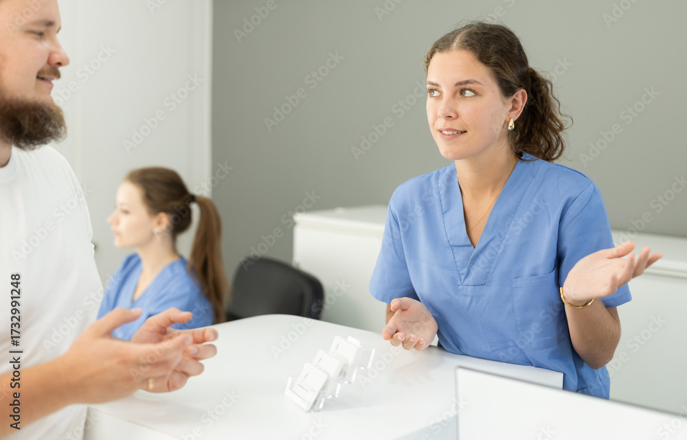 Fototapeta premium Dental clinic administrator talks to patients at the reception desk