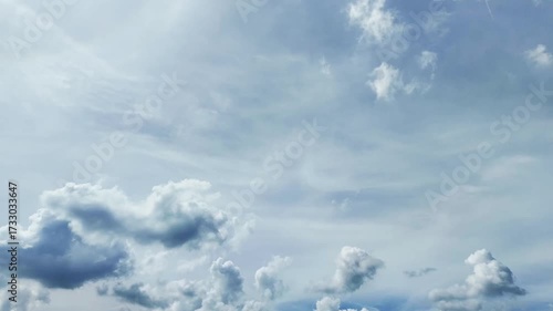 Dynamic sky with fluffy white clouds against a vivid blue backdrop, emphasizing natural beauty and airy atmosphere.Time-lapse video.