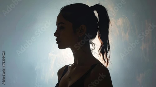 Silhouette of a woman with her hair tied up, looking thoughtful and elegant
