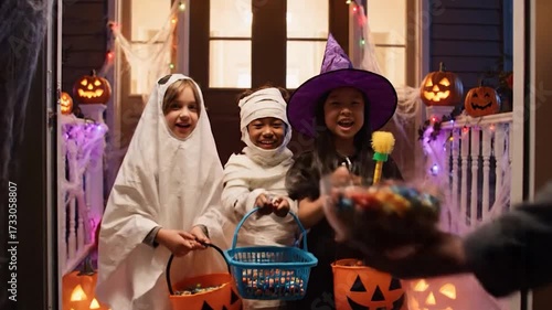 The Magic of Trick-or-Treating Children in Costumes Receiving Candy at a Spooky Front Door
