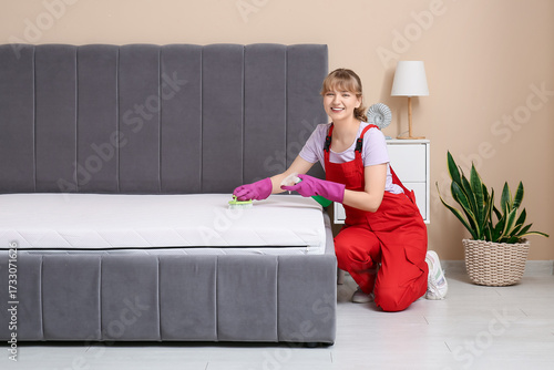 Female janitor cleaning mat...