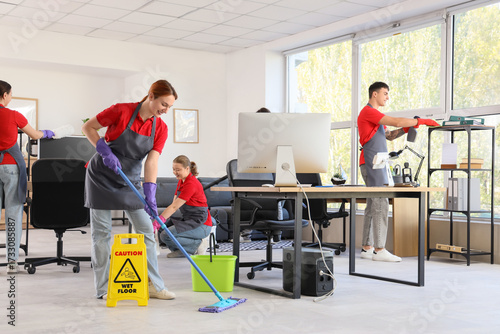 Team of young janitors clea...