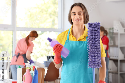 Smiling male cleaner holdin...
