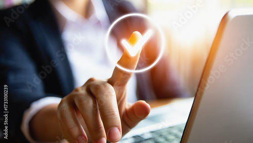 Person's finger taps glowing checkmark icon on screen representing success and digital verification