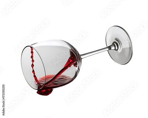 Dramatic red wine spill in a tilted glass on black background with vibrant color and detailed textures