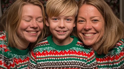Close up of two women and a boy smiling wearing matching christmas sweaters in a festive setting