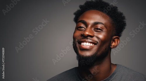 A multicultural individual smiles warmly in a close-up portrait, radiating joy and connection.