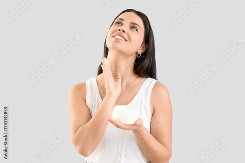 Young woman applying facial...