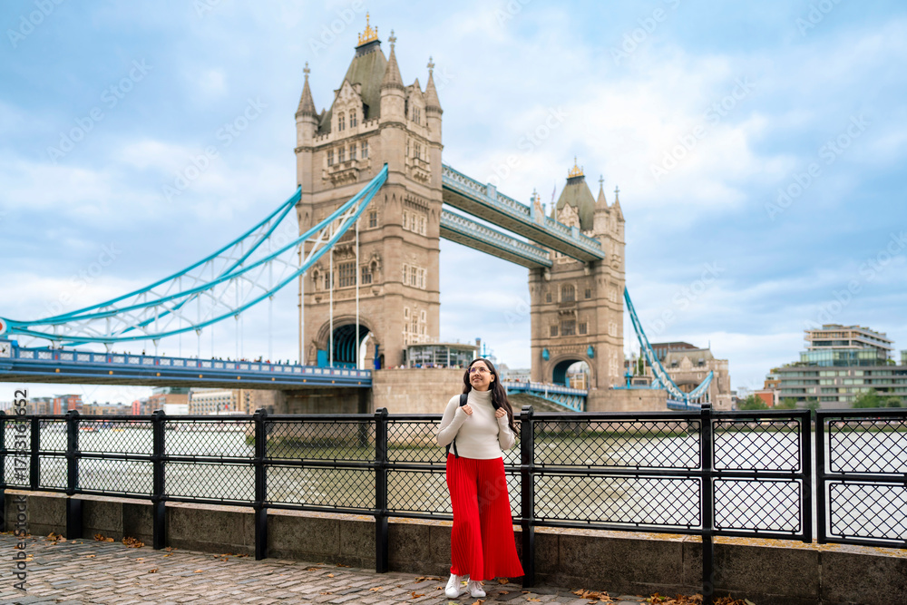 Φωτογραφία Young happy Latina woman stands along the Thames in front of the iconic Tower Bridge in London, England