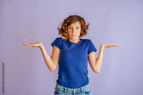 Serious kid expressing choice-making by weighing choices in hands with thoughtful vibe for decision-making on vibrant blue studio background with focused energy