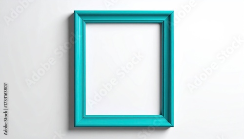 Turquoise empty picture frame with a thick border, hanging on a plain white wall